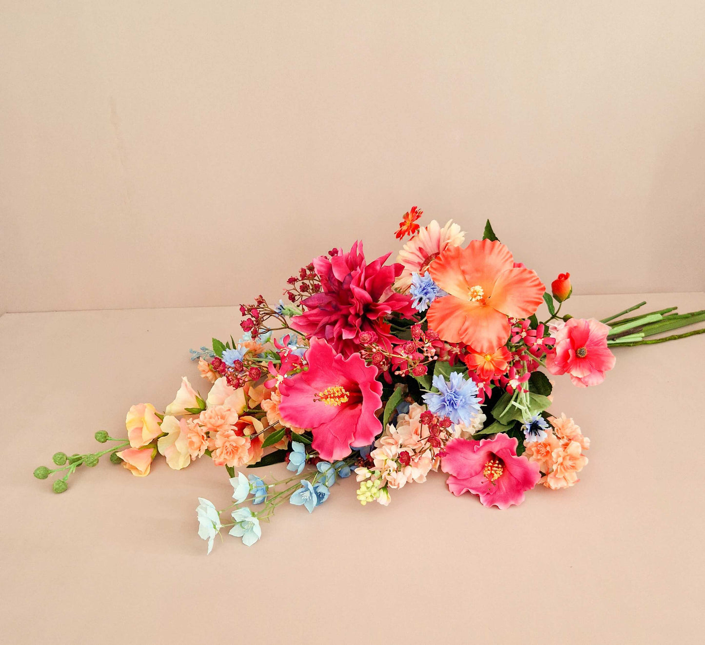 liggend rouwboeket van kunstbloemen in roze en oranje tinten