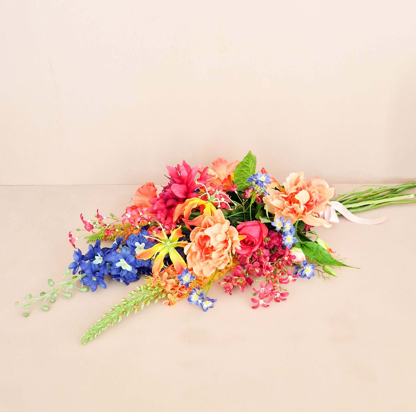 close up van zijden rouwboeket in bonte kleuren eremurus, zonnebloemen en delphinium