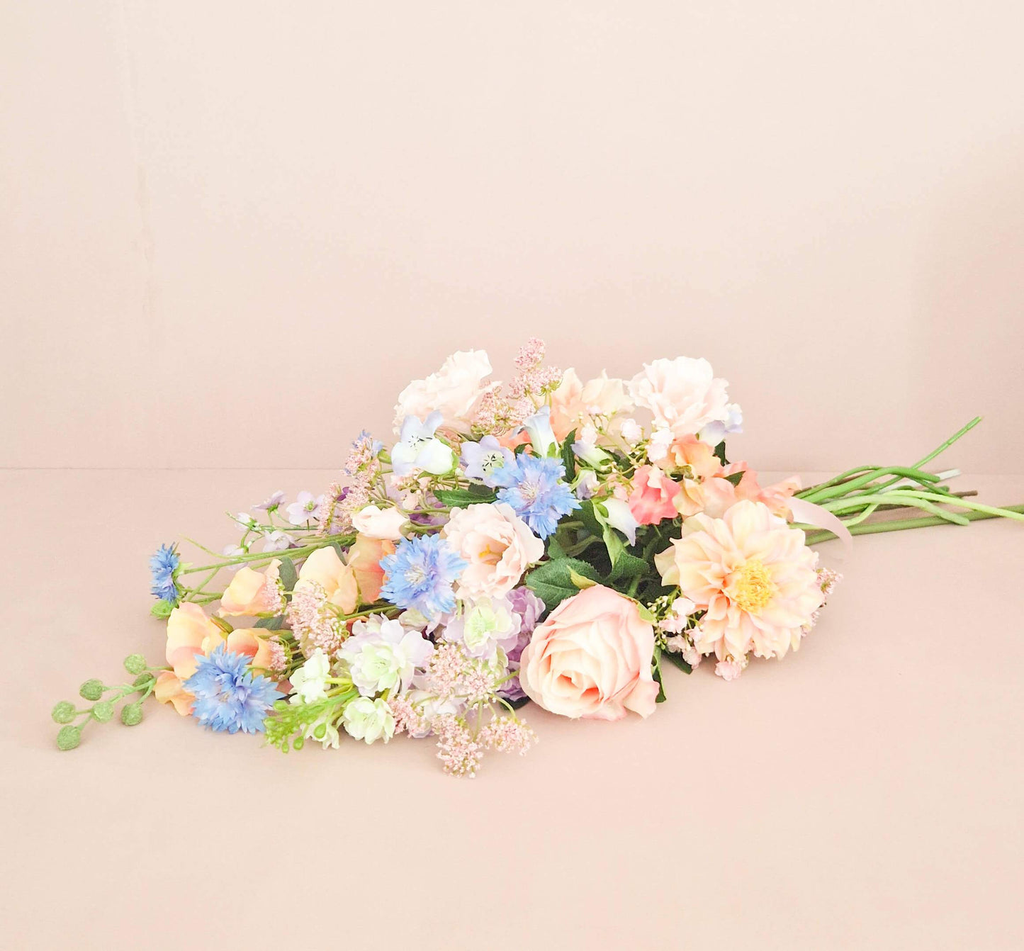 liggend zijden rouwboeket in pastel kleuren licht blauw en roze