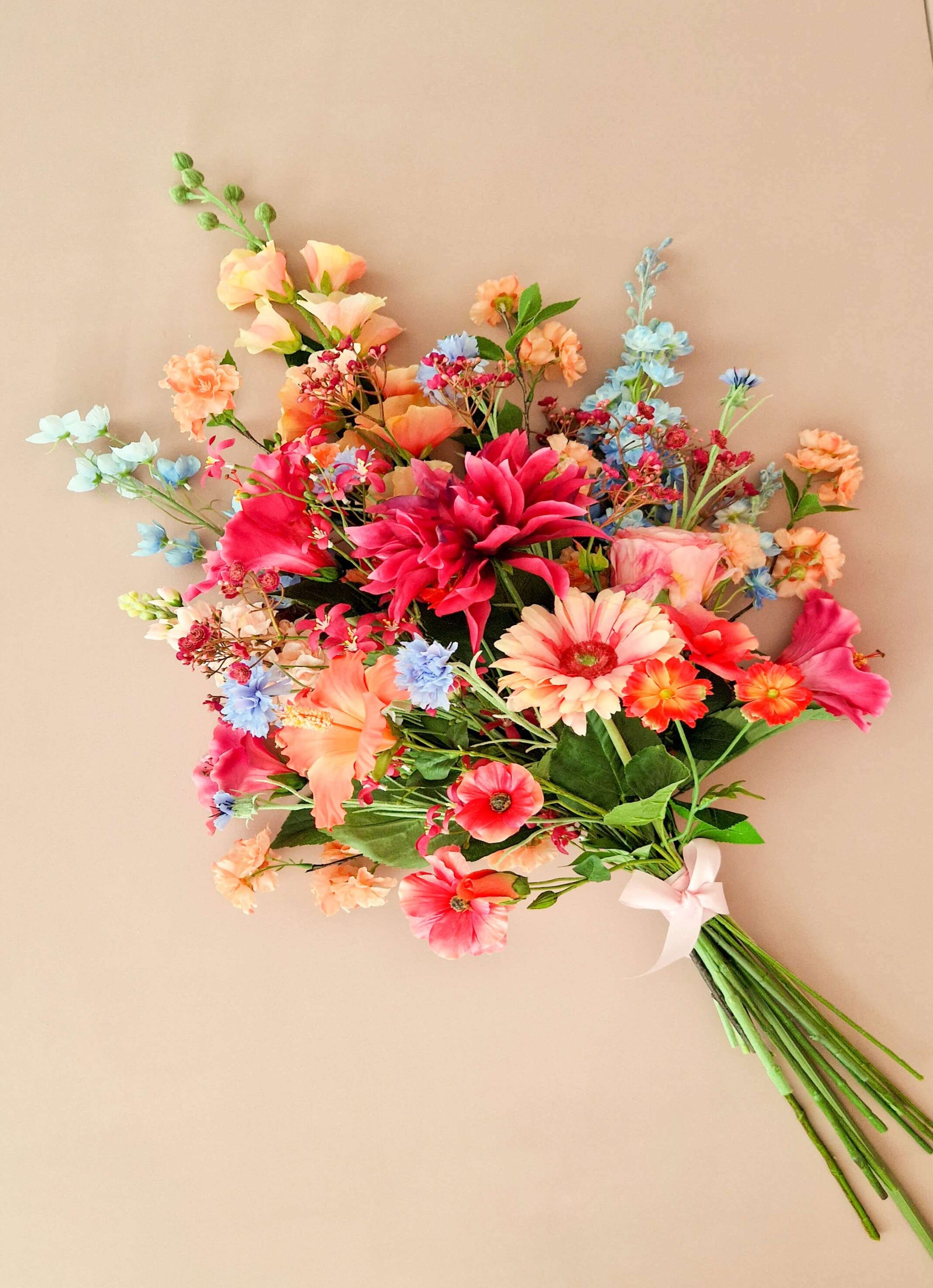 rouwboeket van kunstbloemen in warme kleuren als oranje en roze