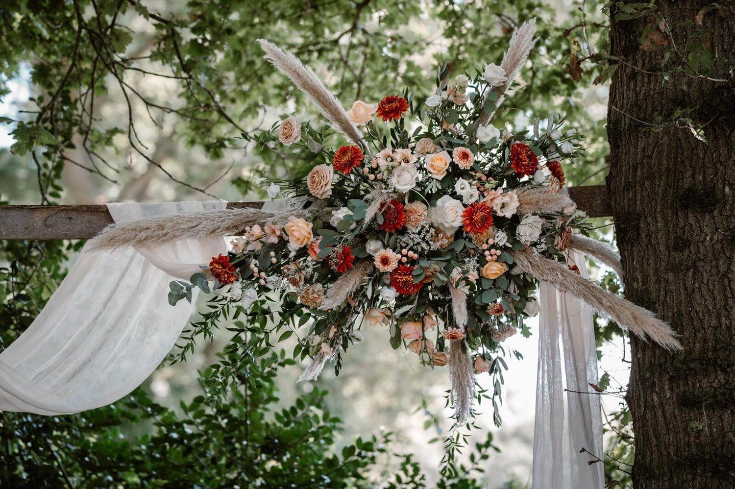 bohemianstijl bloemstuk met grassen en pampas en zachte kleuren bloemen zalm kleurige rozen 