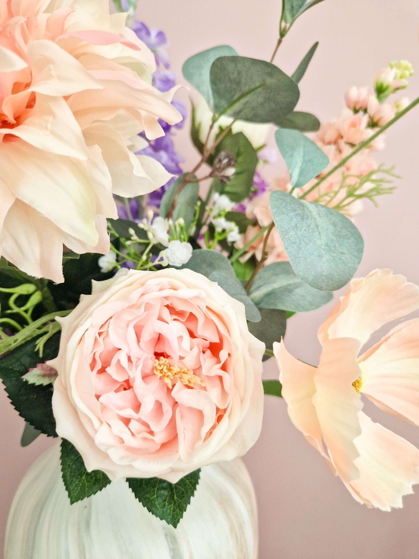 close up van een herdenkingsboeket van zijden bloemen. zacht roze en paarse zijden bloemen en eucalypthus