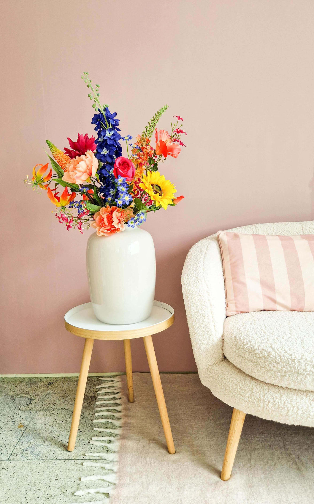 Kleurrijk zijden bloemenboeket met zonnebloemen, delphinium en rozen in witte vaas