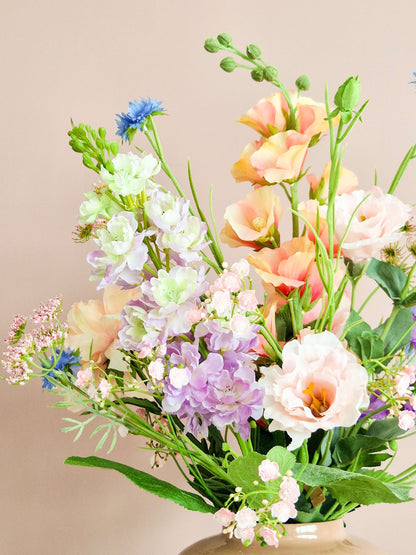 close up van zijden boeket van pastel tinten met delphinium en lisianthus
