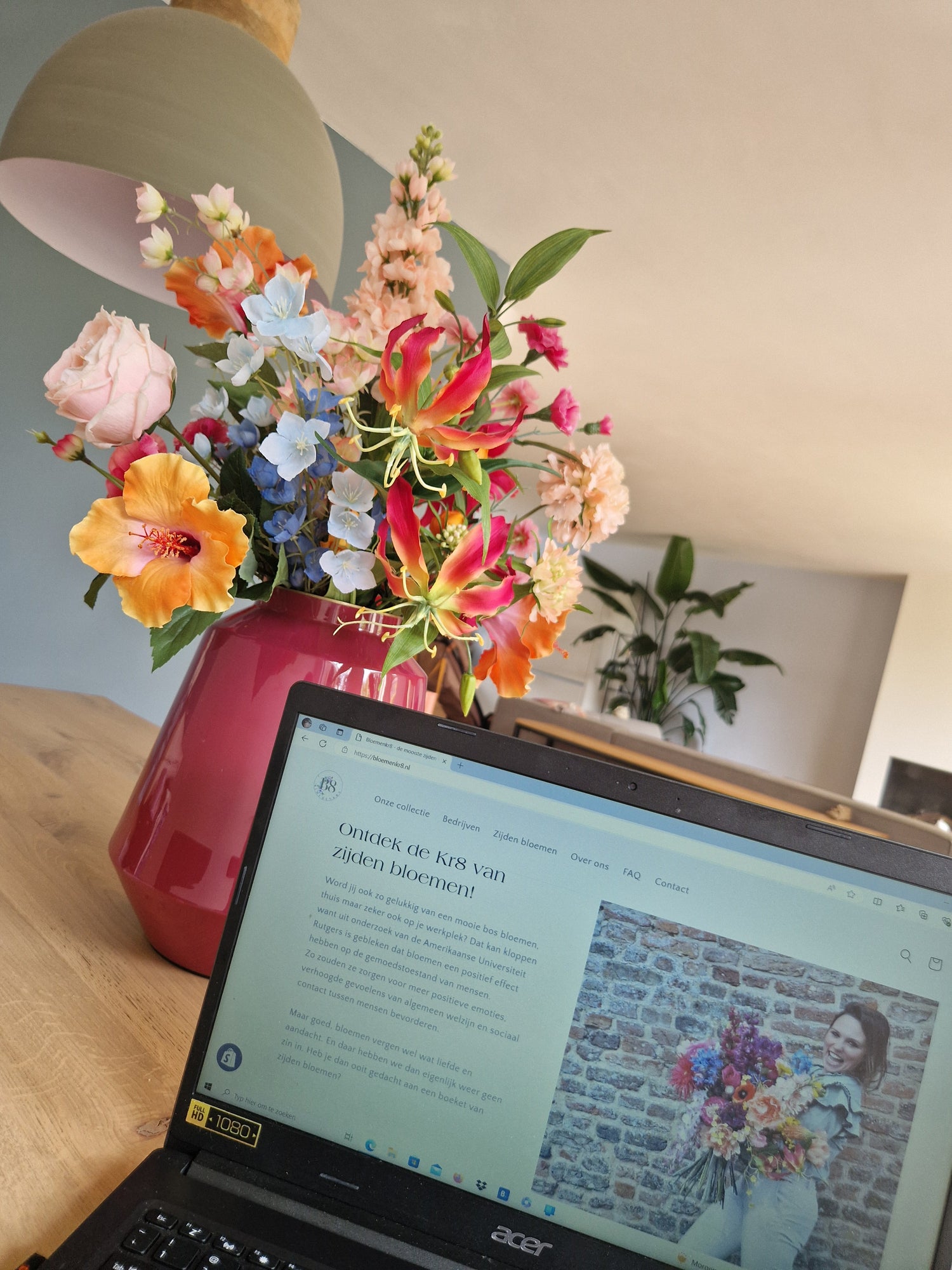 Zijden bloemen op een modern kantoorbureau – sfeervolle en duurzame werkplekdecoratie.