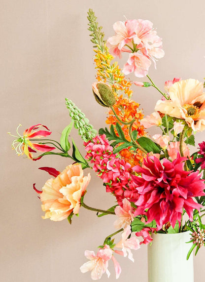 Zijden boeket met roze dahlia, zalmkleurige papaver, oranje eremurus, roze lupine en gloriosa.