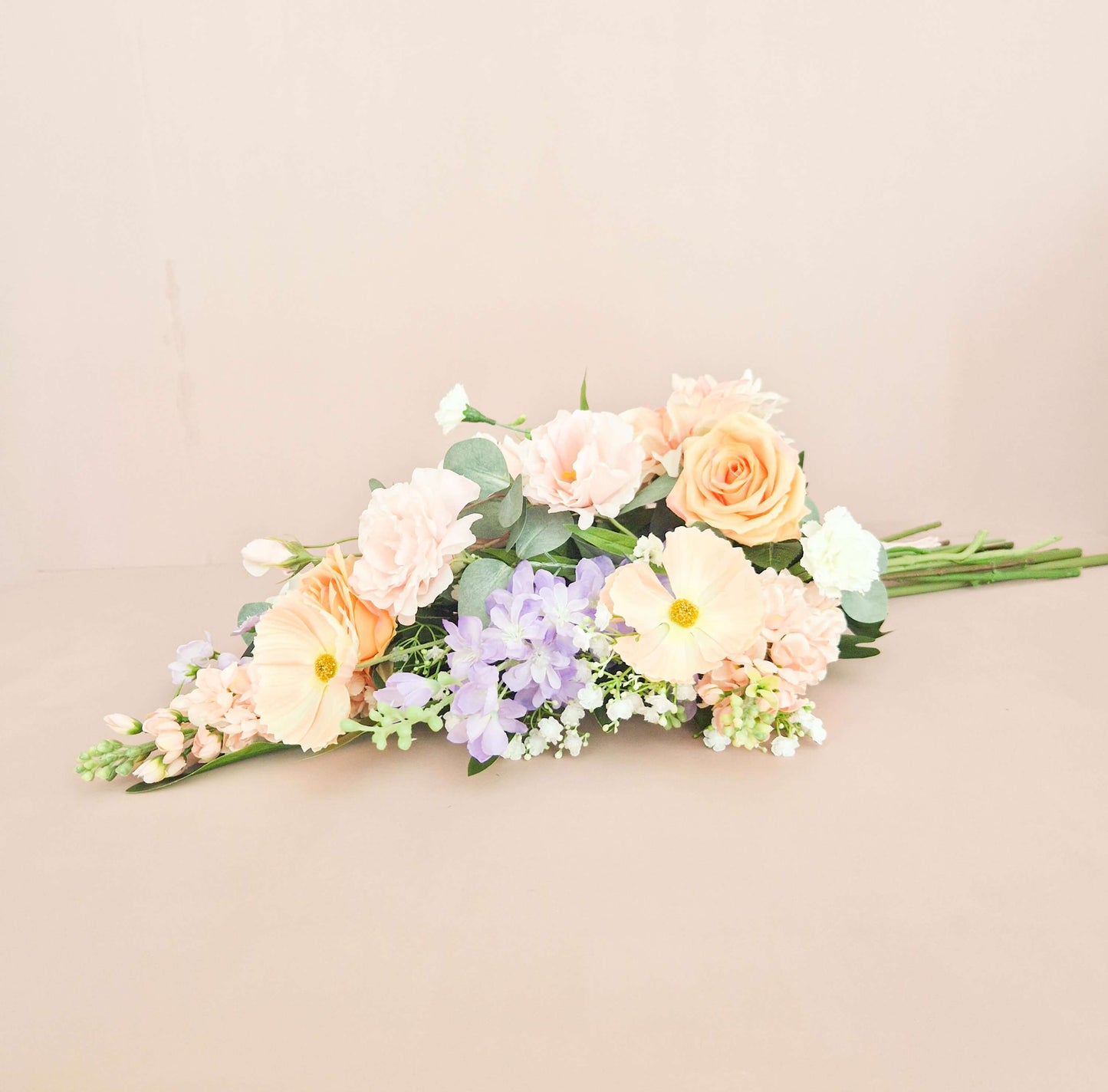 liggend zijden rouwboeket in lichte kleuren roze, paars en wit