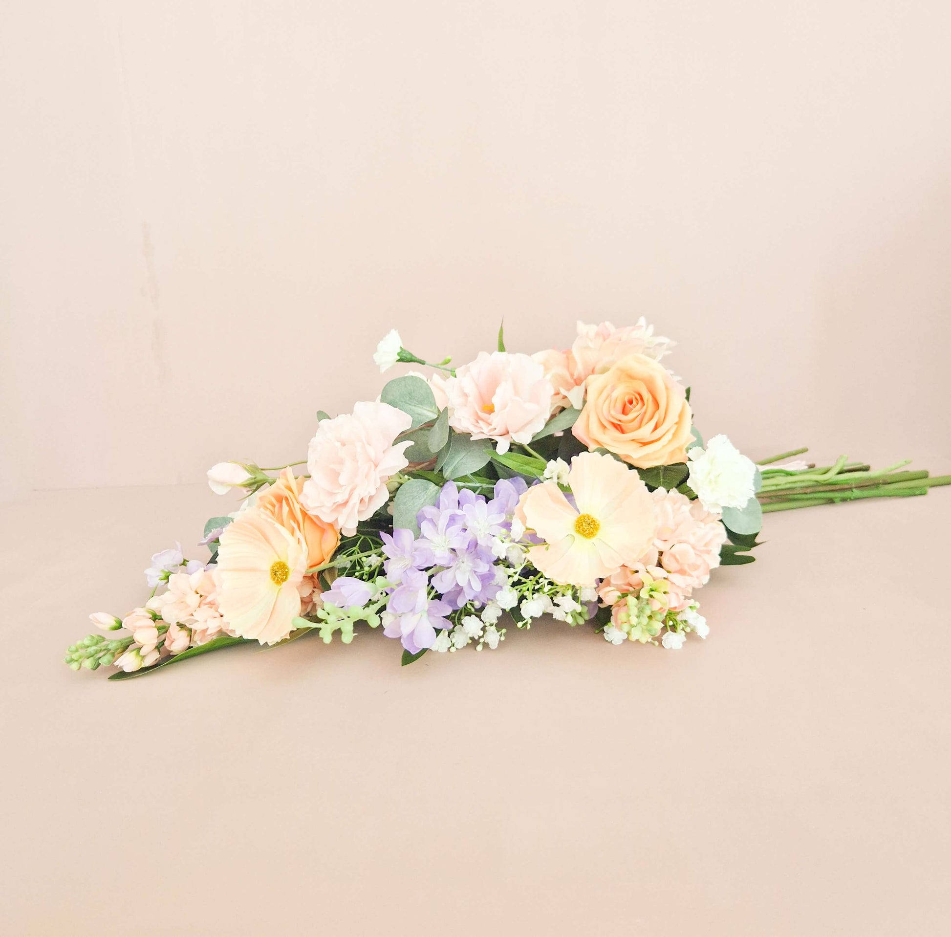 liggend zijden rouwboeket in lichte kleuren roze, paars en wit